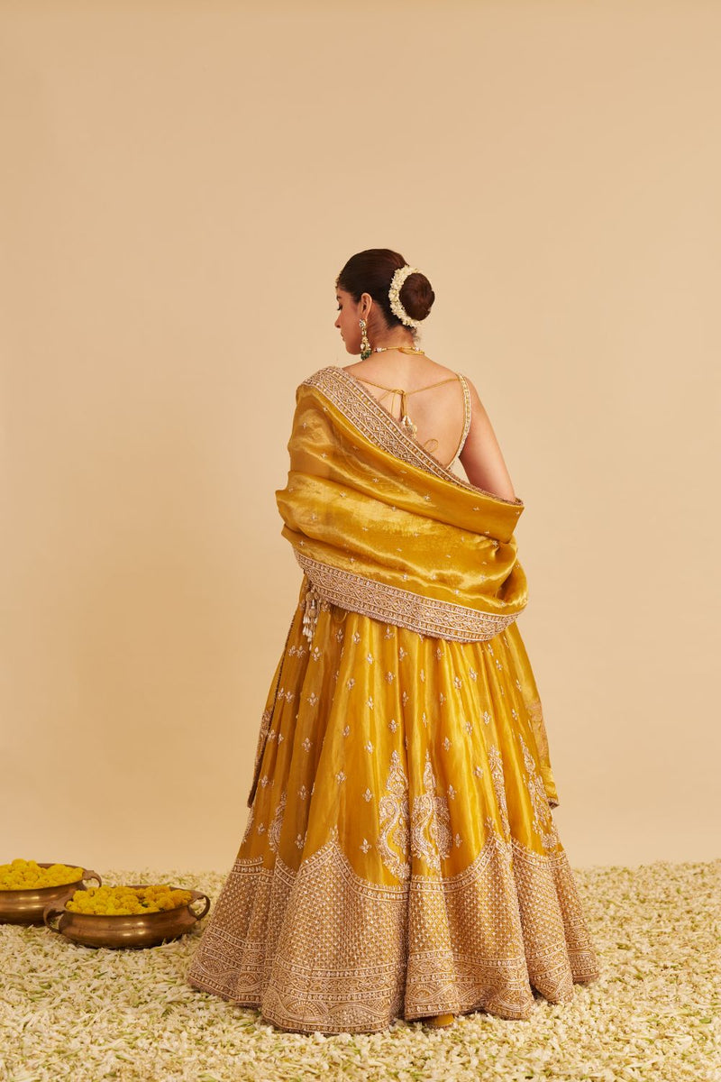 Aashina - Dabka Zardozi Embroidered Pure Tissue Mustard Lehenga Set silk by SHEETAL BATRA in gold color for women Worldwide