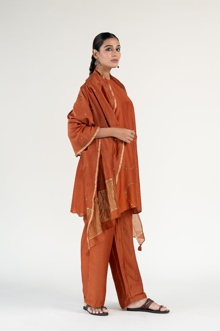 Mehr Kurta Set 
with Ayra Odhani-Rust silk by Nirjara in rust color for women Worldwide